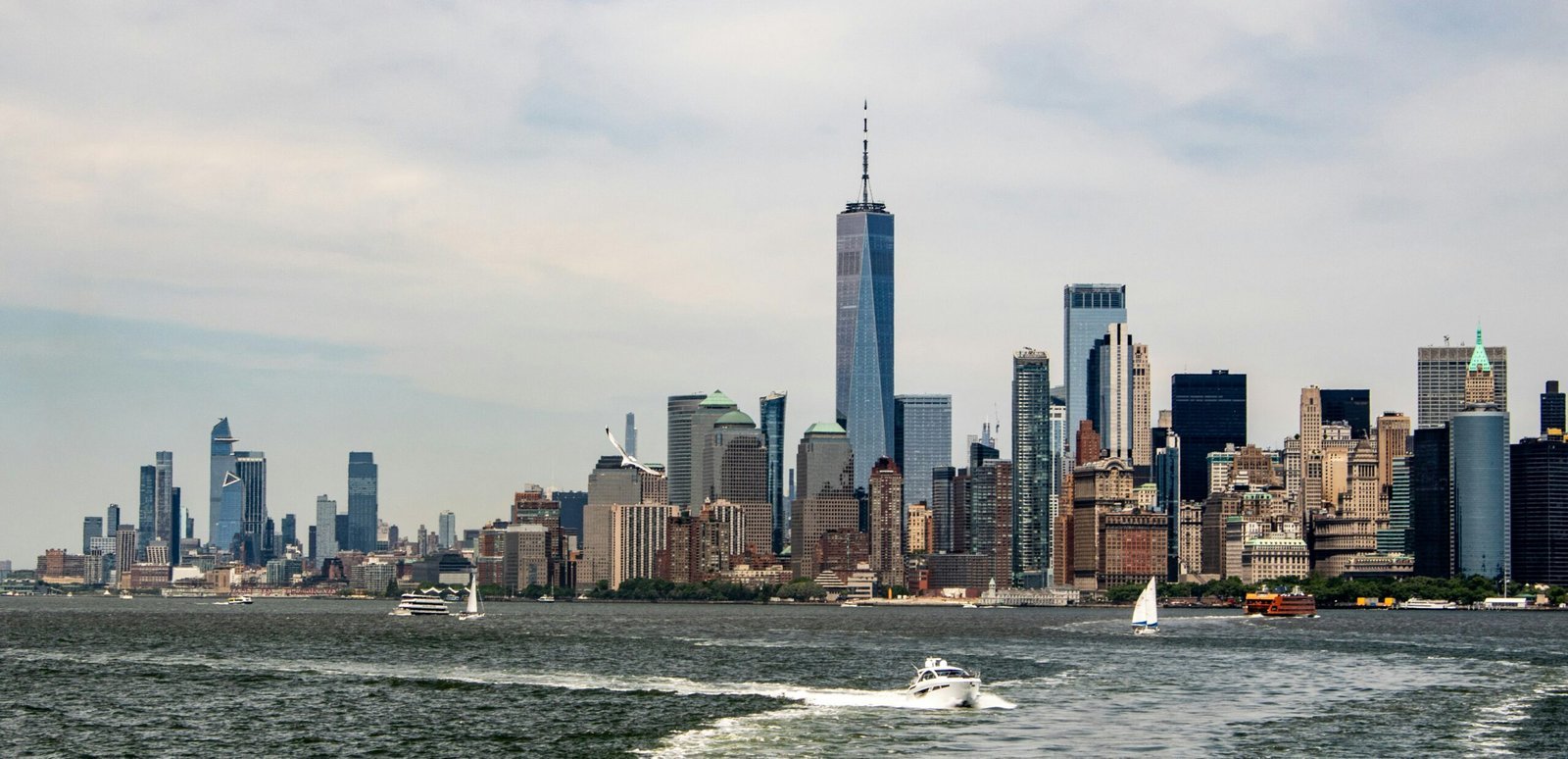 A boat is in the water near a large city